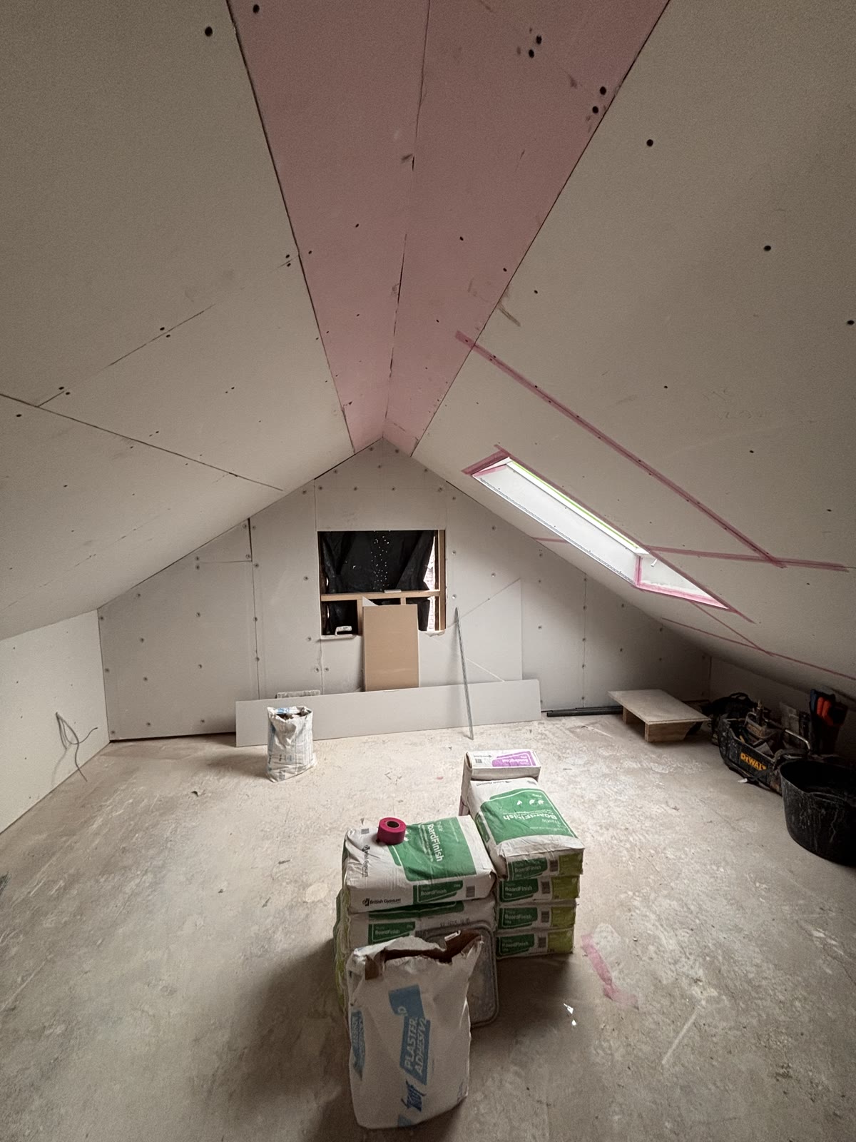 A boarded-out loft room in Stalybridge with plaster stacked, ready for skimming