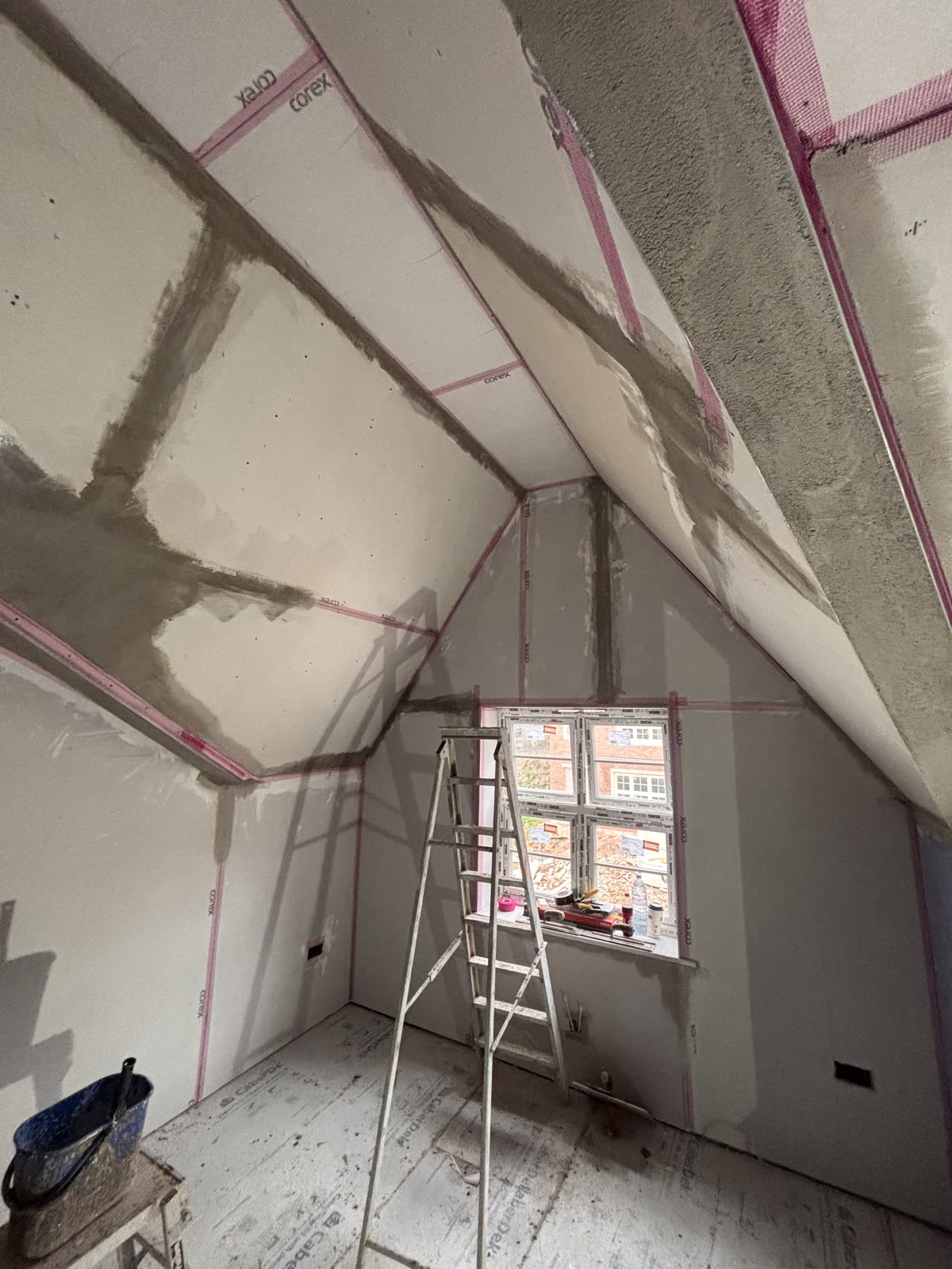 Angle beads set to the lines of a vaulted ceiling and filled