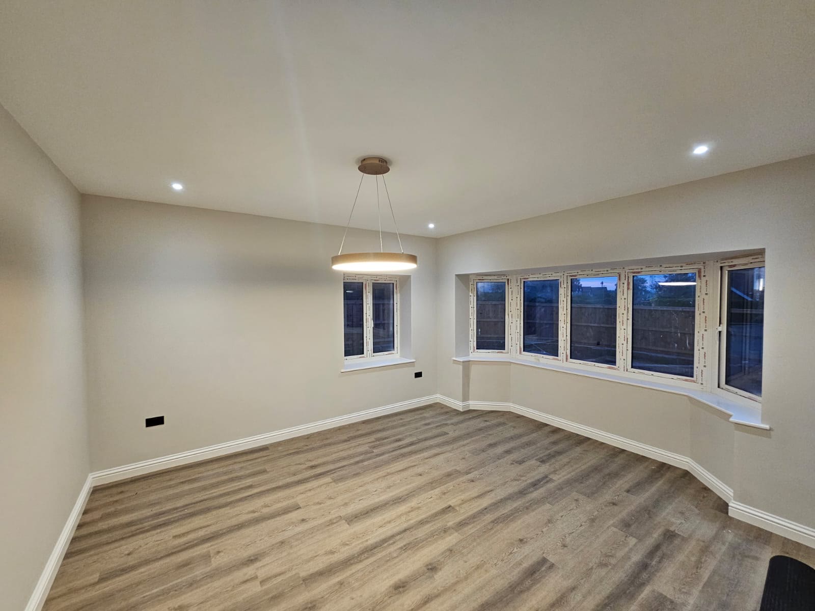 A finished lounge with smooth plastered walls and ceiling after a full refurbishment