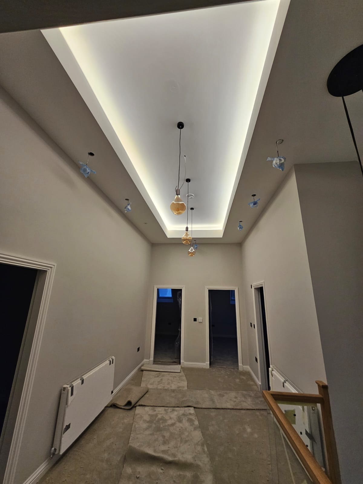 A feature tray ceiling with concealed cove lighting, plastered and finished