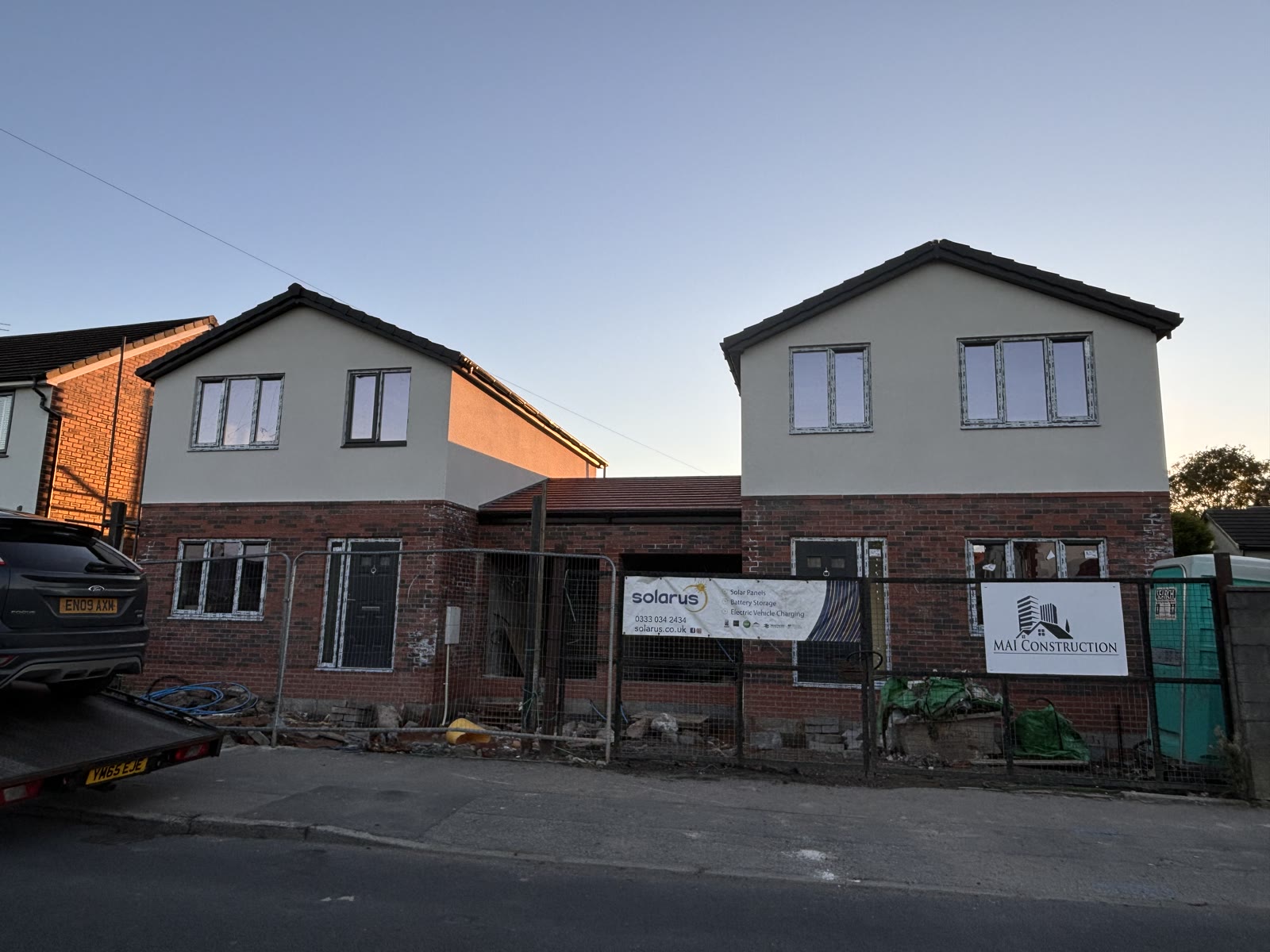 A pair of new build houses finished in render above brick