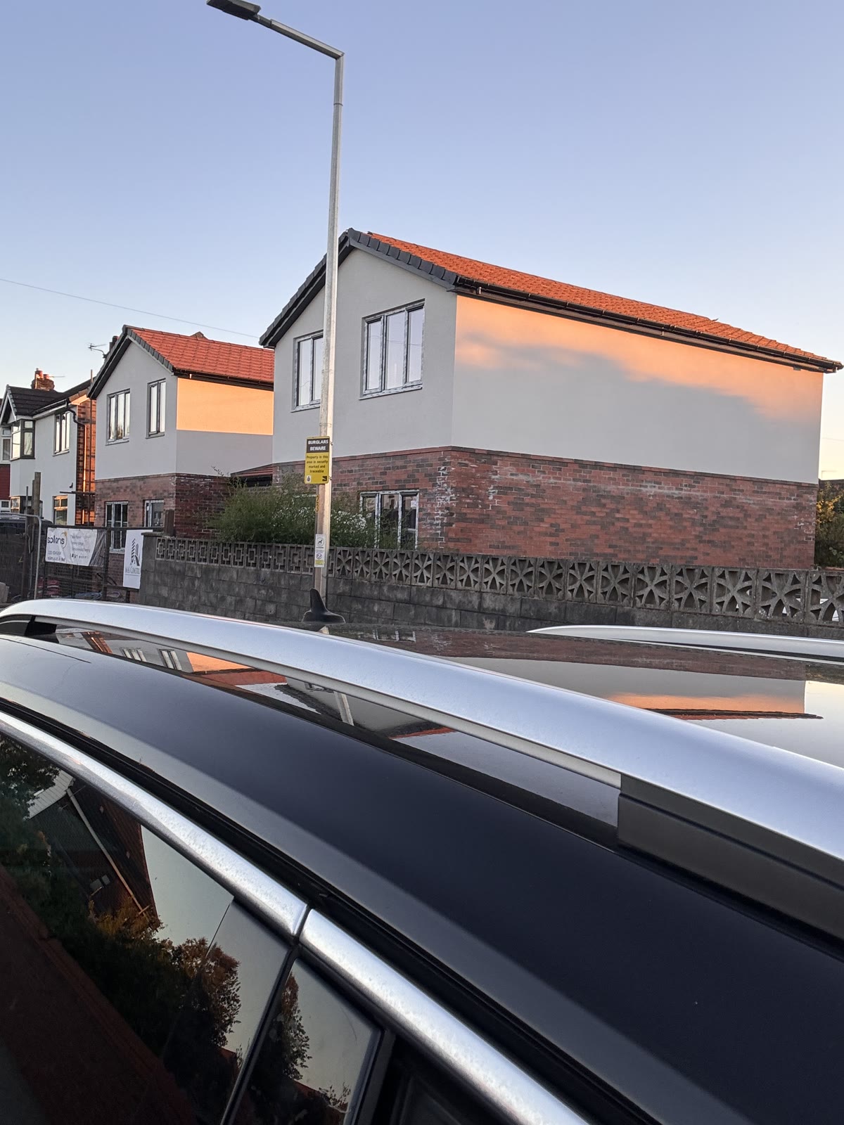 Two new build houses rendered above brick, seen from the street