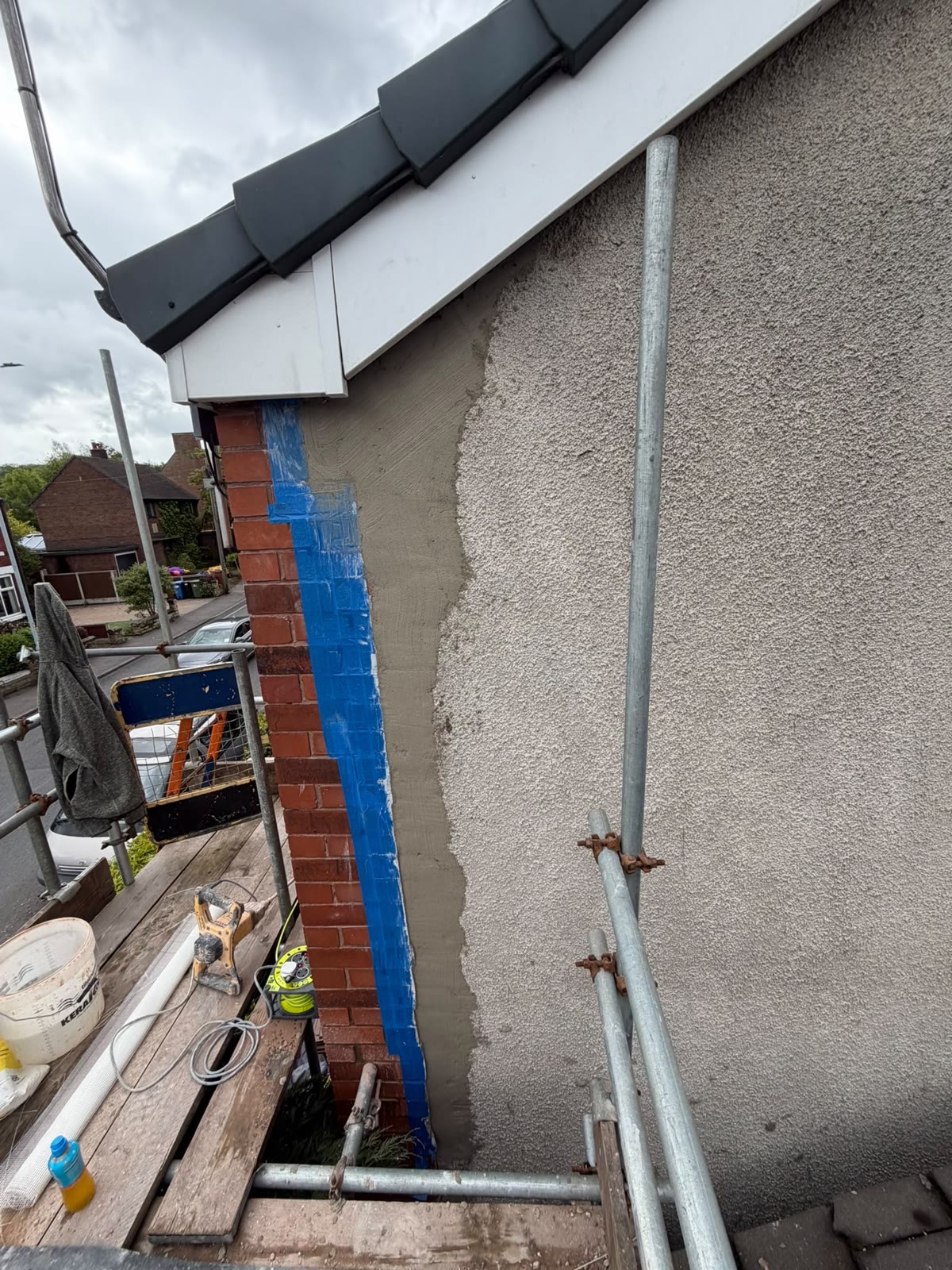 New render being applied to the cut-back area with the brickwork masked off