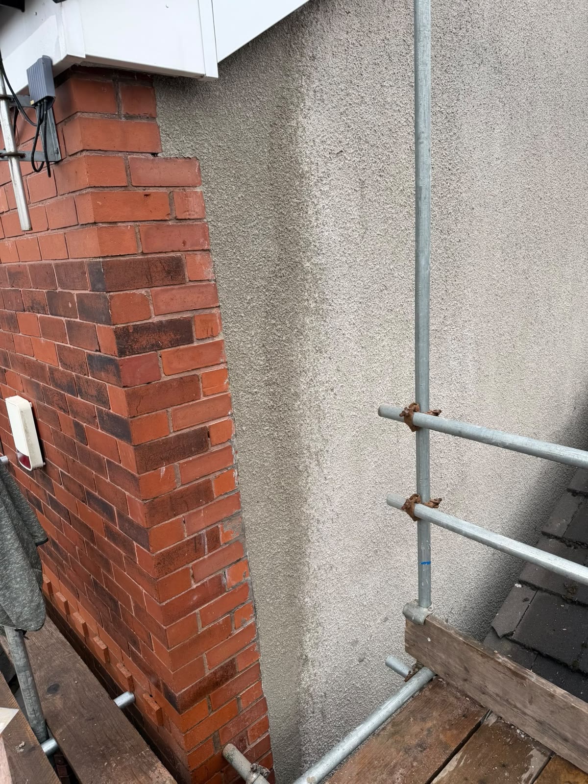 The finished repair, render meeting the brick pier in a clean straight line